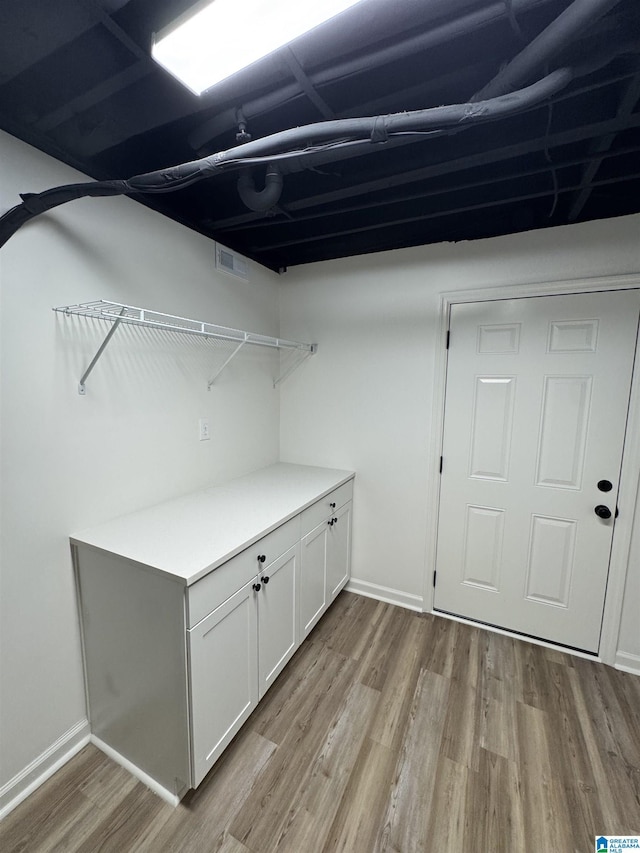 washroom with visible vents, light wood-style flooring, and baseboards