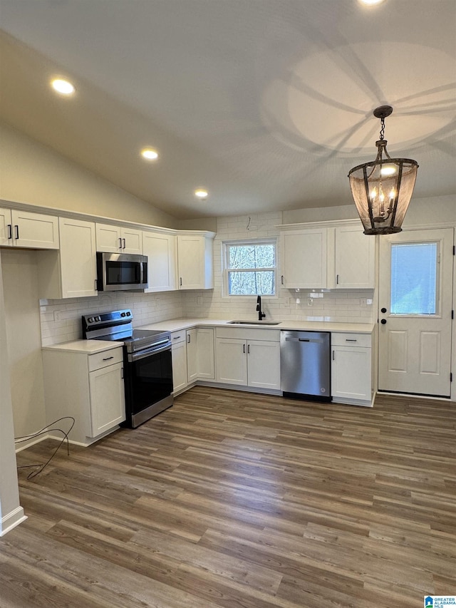 kitchen featuring appliances with stainless steel finishes, white cabinets, and a sink