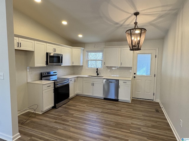 kitchen featuring white cabinetry, appliances with stainless steel finishes, dark wood finished floors, and a sink