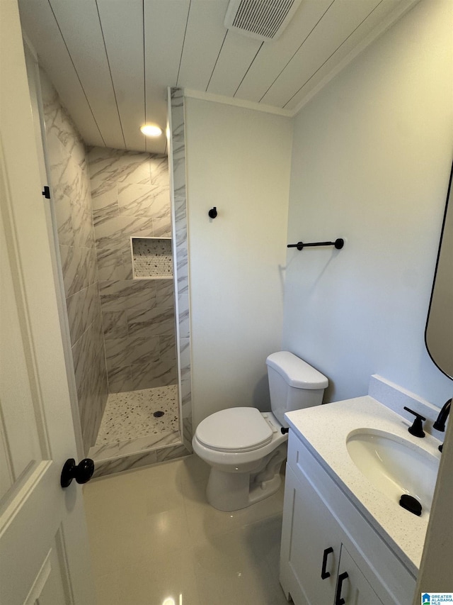 full bath featuring toilet, visible vents, tiled shower, and vanity