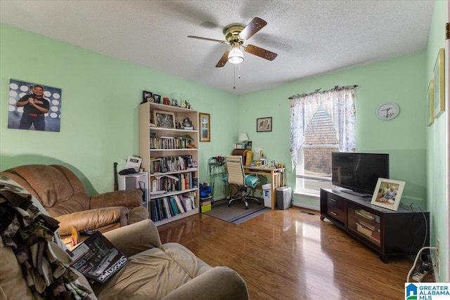 interior space with a ceiling fan, a textured ceiling, and wood finished floors