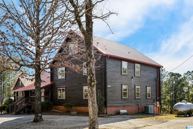 view of home's exterior featuring central air condition unit and metal roof