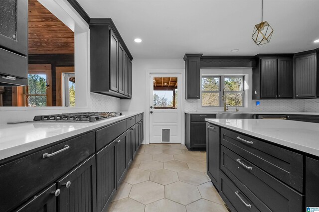 kitchen featuring light tile patterned floors, tasteful backsplash, light countertops, stainless steel gas cooktop, and recessed lighting