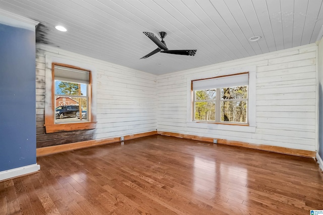 unfurnished room featuring wooden ceiling, wood finished floors, a ceiling fan, and baseboards