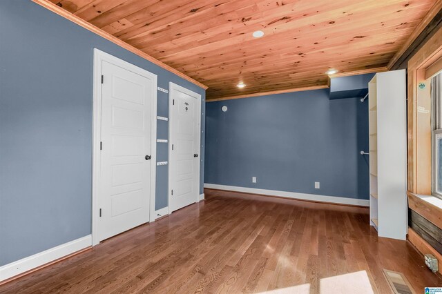 unfurnished bedroom featuring baseboards, visible vents, wood ceiling, ornamental molding, and wood finished floors