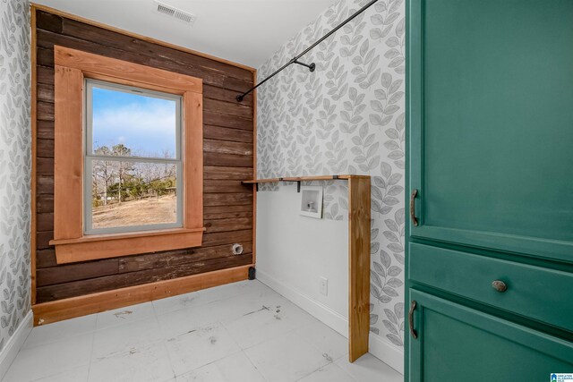 bathroom featuring visible vents, wood walls, and baseboards