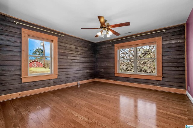 unfurnished room featuring baseboards, a ceiling fan, and wood finished floors