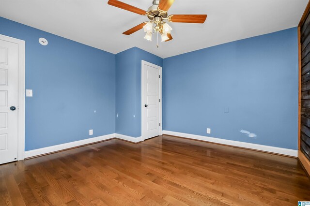 spare room featuring a ceiling fan, baseboards, and wood finished floors