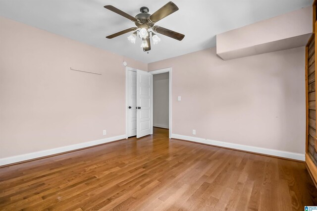 spare room with a ceiling fan, baseboards, and wood finished floors