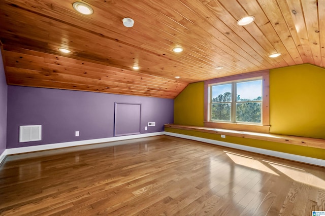 bonus room with baseboards, visible vents, vaulted ceiling, and wood finished floors