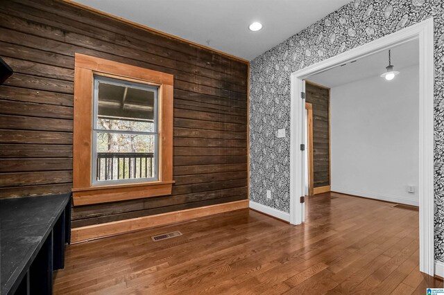 unfurnished room featuring visible vents, baseboards, and wood finished floors