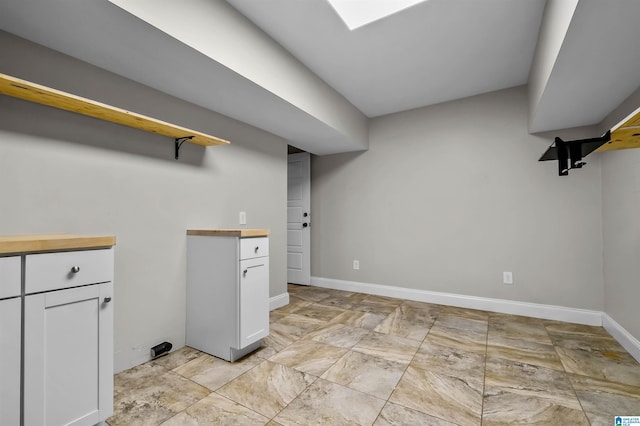 clothes washing area with baseboards