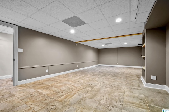 finished below grade area with recessed lighting, a paneled ceiling, and baseboards