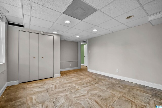 interior space featuring a closet, recessed lighting, a paneled ceiling, and baseboards