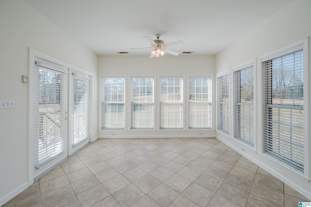 unfurnished sunroom with visible vents, a ceiling fan, and a wealth of natural light