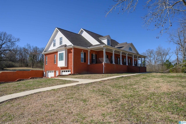 view of side of property featuring a garage, a porch, a lawn, and brick siding