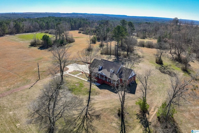 drone / aerial view featuring a rural view and a view of trees