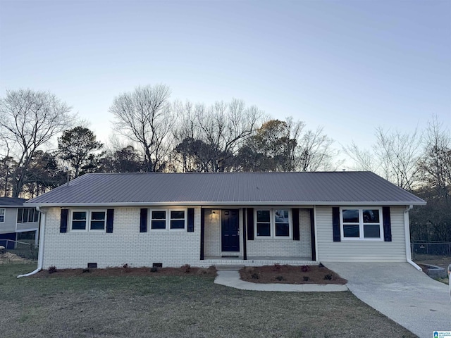 ranch-style house with crawl space, brick siding, metal roof, and a front lawn