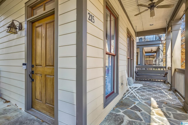 entrance to property with ceiling fan and a porch