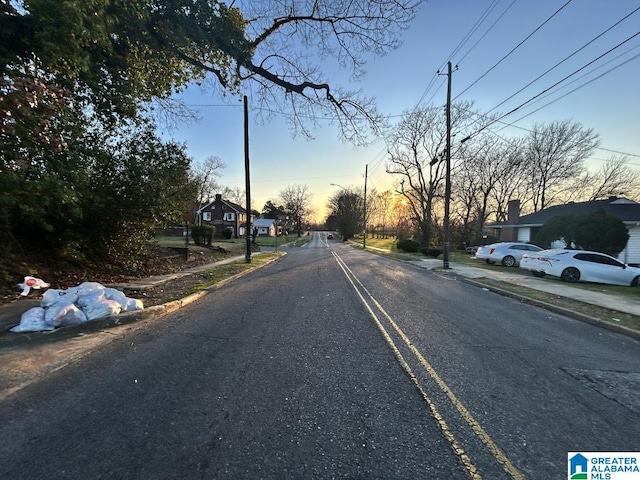 view of street with street lights, curbs, and sidewalks