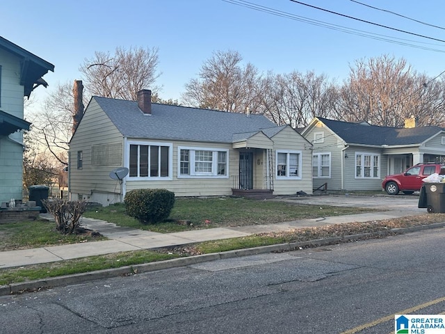 view of front of house featuring roof with shingles and a chimney