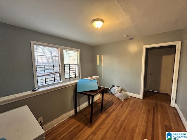 interior space with baseboards and wood finished floors