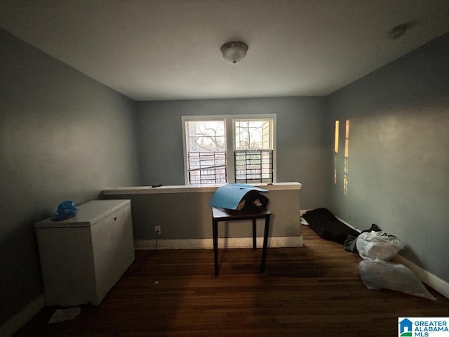 office space with baseboards and wood finished floors