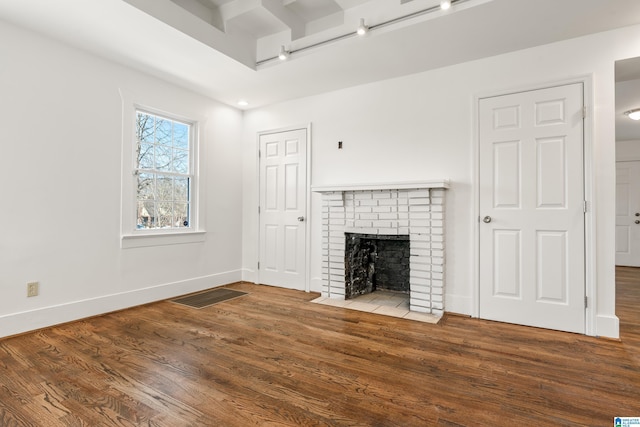 unfurnished living room with a fireplace, wood finished floors, visible vents, and baseboards
