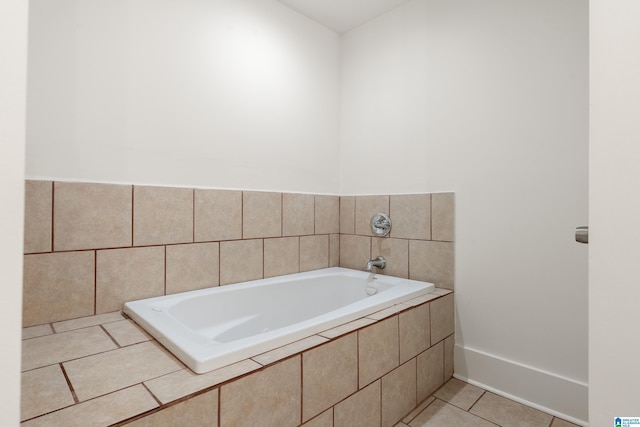bathroom with a garden tub, baseboards, and tile patterned floors