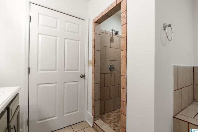 full bathroom with tiled shower, vanity, and tile patterned floors