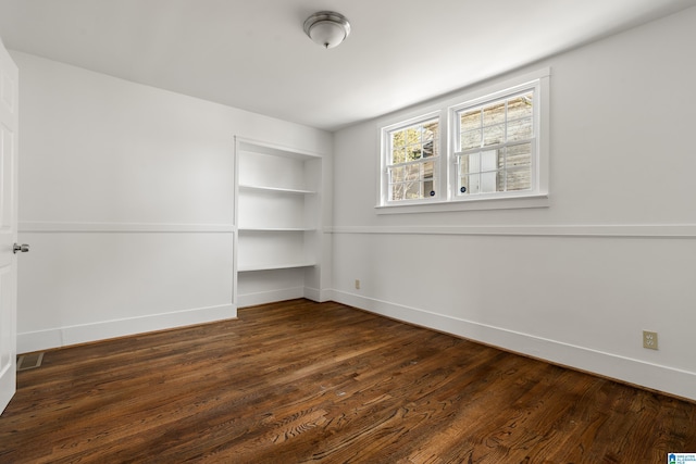 unfurnished room featuring baseboards and wood finished floors