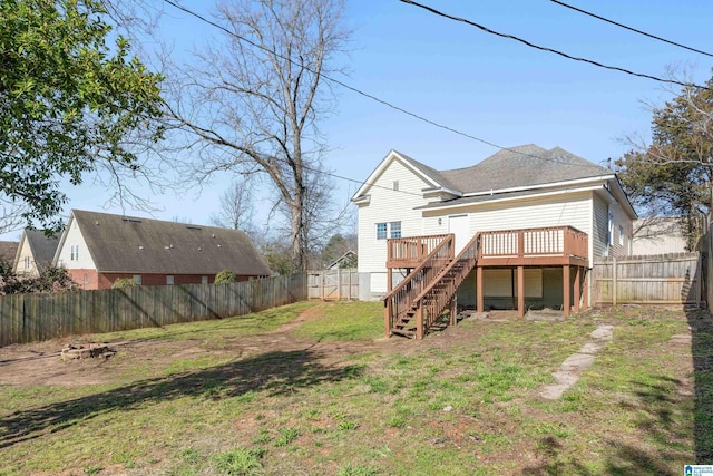 back of house with a fenced backyard, a yard, stairway, and a wooden deck