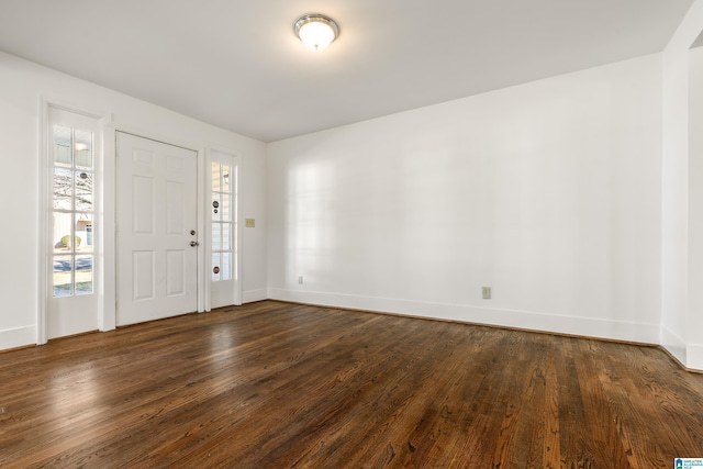 foyer featuring dark wood finished floors and baseboards