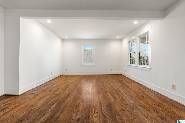 empty room with baseboards, dark wood finished floors, and recessed lighting