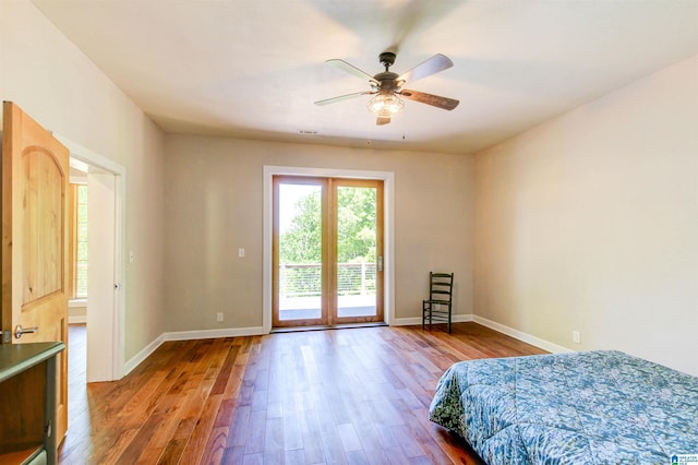 bedroom with visible vents, baseboards, ceiling fan, wood finished floors, and access to exterior