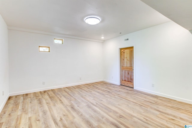 spare room featuring light wood-style floors and baseboards