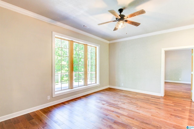 empty room featuring baseboards, ornamental molding, visible vents, and light wood-style floors