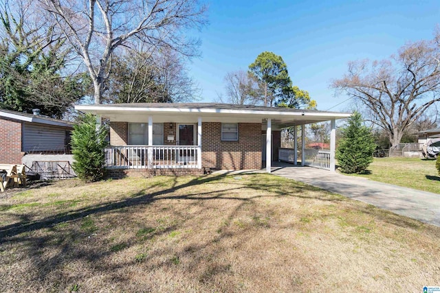 view of front of home featuring an attached carport, covered porch, brick siding, driveway, and a front yard