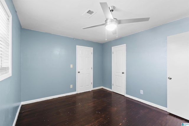 unfurnished room featuring a ceiling fan, visible vents, baseboards, and wood finished floors