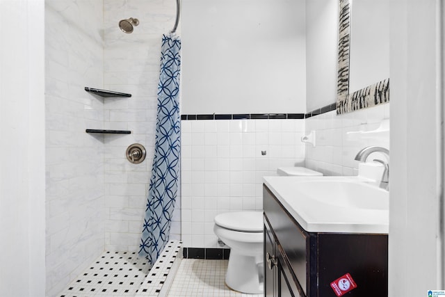 full bath with a stall shower, vanity, toilet, and tile walls