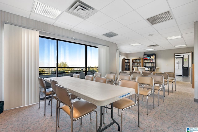 dining space featuring a paneled ceiling, carpet, and visible vents