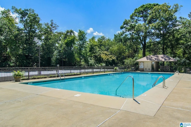 community pool with fence and a patio