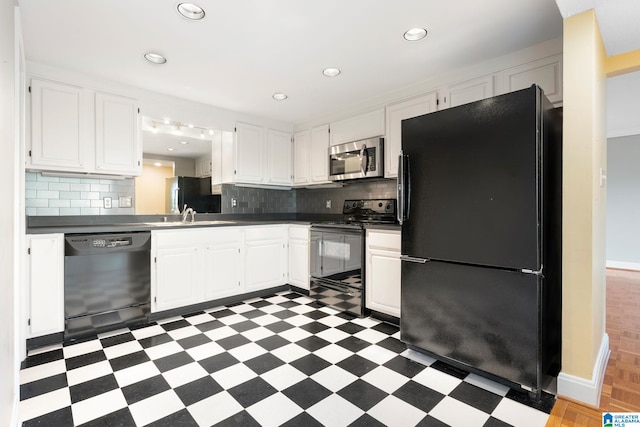 kitchen with light floors, a sink, black appliances, tasteful backsplash, and dark countertops