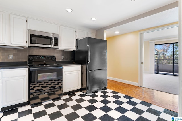 kitchen with stainless steel microwave, dark countertops, freestanding refrigerator, and black electric range oven