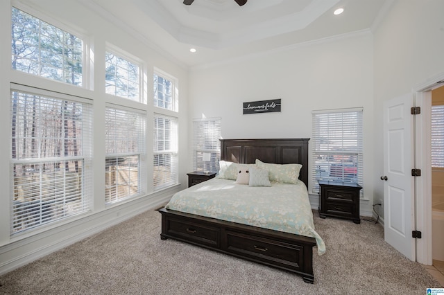 bedroom with a towering ceiling, multiple windows, and light colored carpet