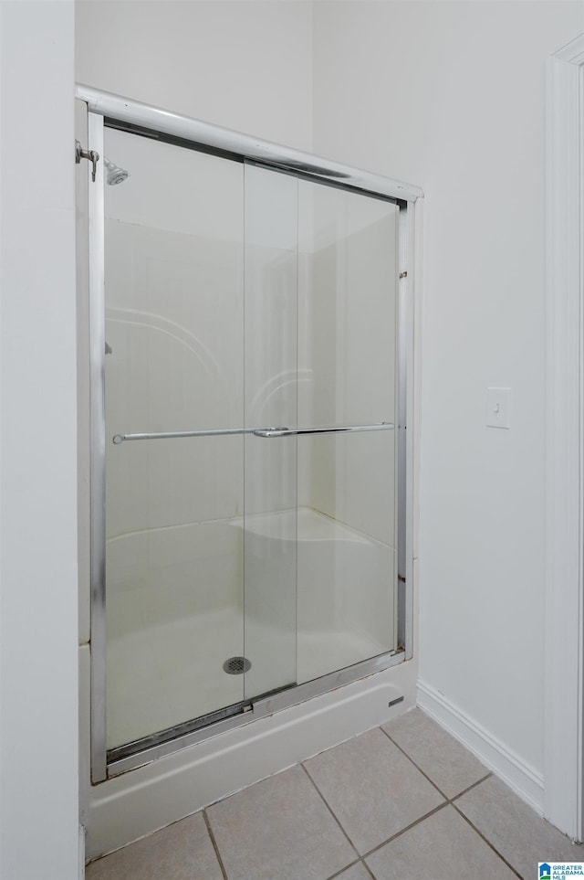 full bathroom with tile patterned flooring, a shower stall, and baseboards