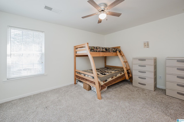 carpeted bedroom featuring baseboards, visible vents, and ceiling fan