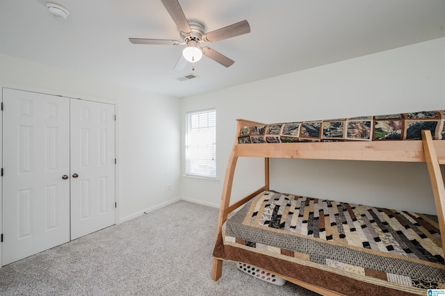 bedroom with ceiling fan, carpet flooring, visible vents, baseboards, and a closet