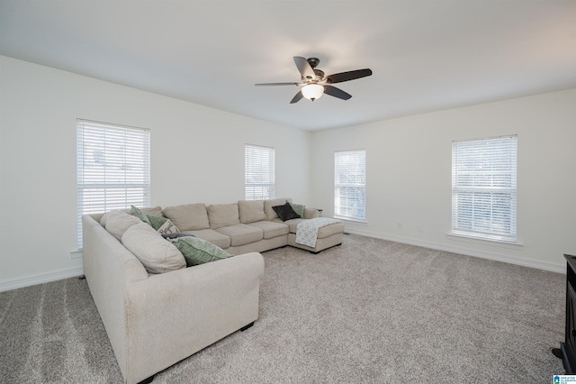 living room with carpet flooring, a ceiling fan, and baseboards