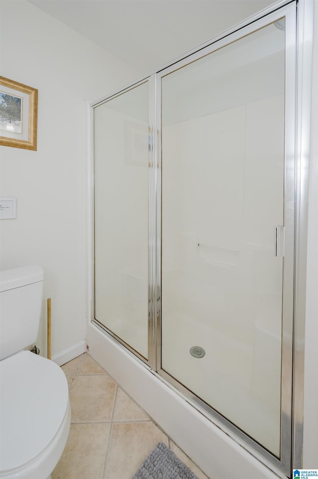 full bath with baseboards, a stall shower, toilet, and tile patterned floors